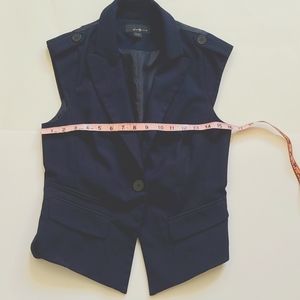 Vest with button details on shoulder.